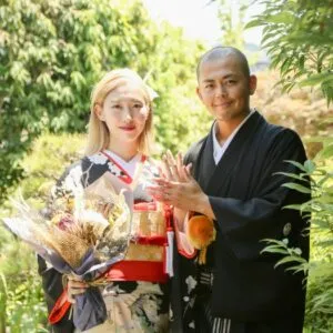 花束を手に微笑む和装のおふたり|伊勢おかげさま婚